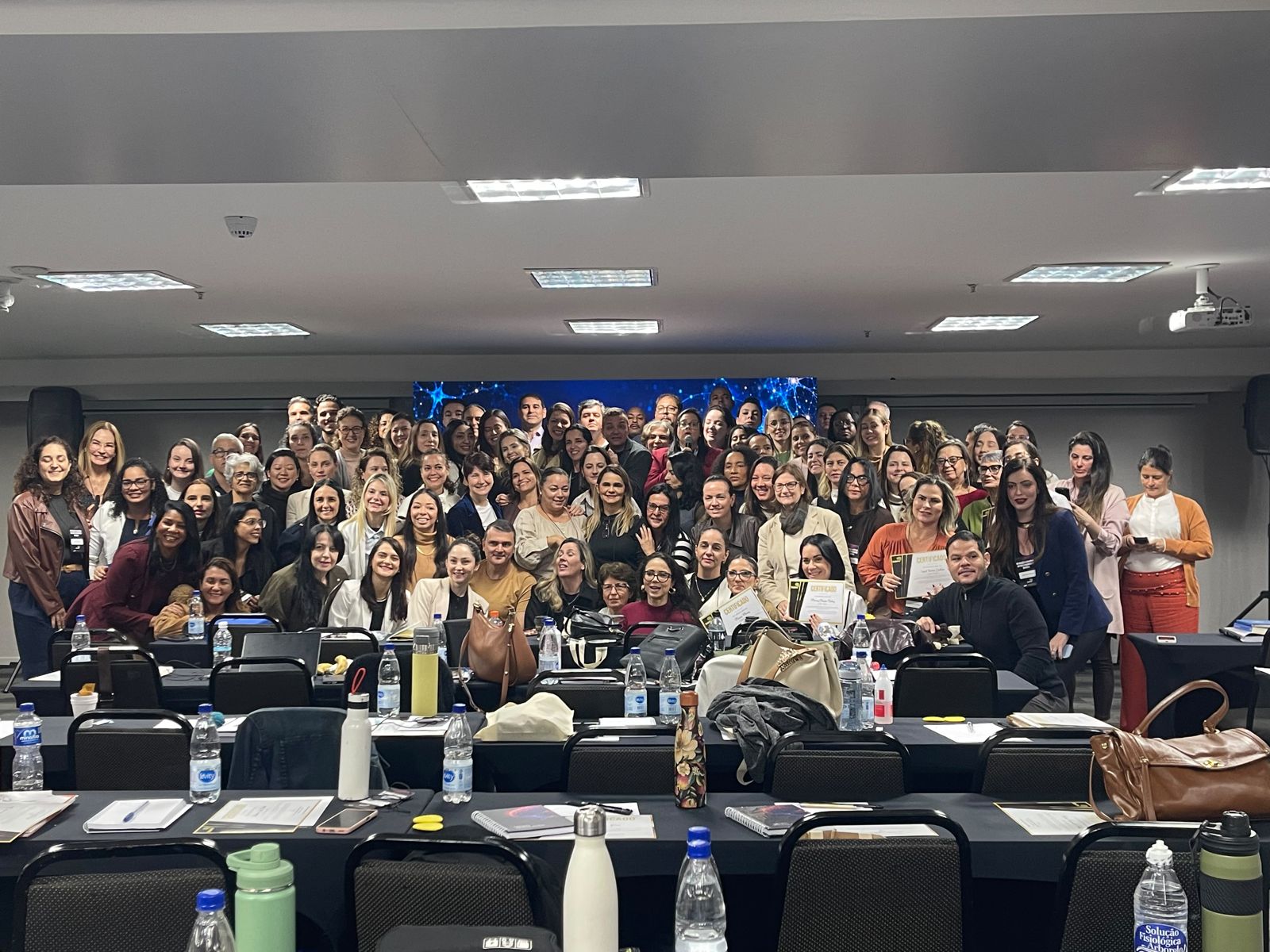 Natalia Mendes com participantes de um evento presencial